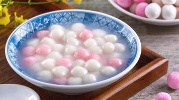 Close up of red and white tangyuan in blue bowl on wooden background for Winter solstice. photo