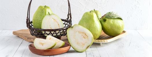 Delicious guava fruit set on white wooden table background with copy space. photo