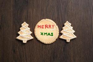 Top view of decorated Christmas tree cookie on wooden table background with copy space. photo