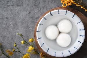 vista superior del gran tangyuan yuanxiao en un tazón sobre fondo gris para la comida del año nuevo lunar. foto