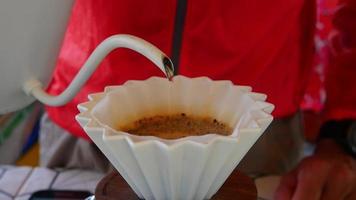 Man pouring hot water into ground coffee beans - people homemade fresh brewed paper hand drip coffee footage video