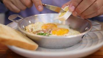 l'homme mange du pain avec une poêle à œufs frits, les gens du restaurant de petit-déjeuner de l'hôtel video