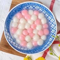 Top view of red and white tangyuan in blue bowl on white background for Winter solstice. photo