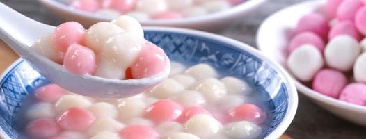 Close up of red and white tangyuan in blue bowl on wooden background for Winter solstice. photo