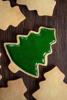 Top view of decorated Christmas tree cookie on wooden table background with copy space. photo