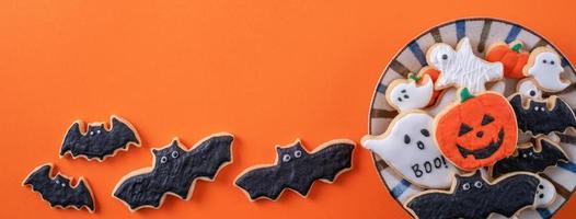 Top view of Halloween festive decorated icing sugar cookies on orange background. photo