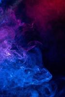 Conceptual image of colorful red and blue color smoke on dark black background. photo