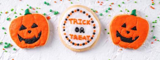 Top view of Halloween festive decorated icing sugar cookies on white background. photo