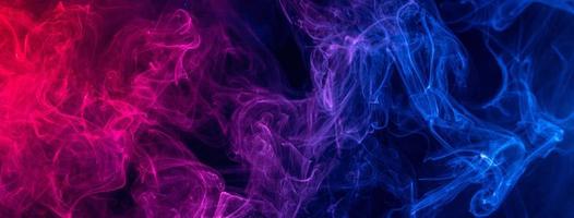Conceptual image of colorful red and blue color smoke on dark black background. photo