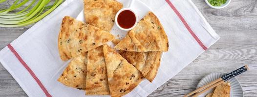 Taiwanese delicious scallion pancake over wooden table background photo