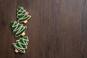 Top view of decorated Christmas tree cookie on wooden table background with copy space. photo