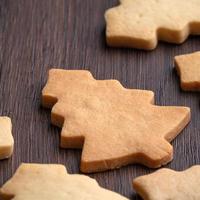 Top view of decorated Christmas tree cookie on wooden table background with copy space. photo