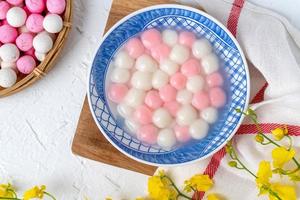 Top view of red and white tangyuan in blue bowl on white background for Winter solstice. photo