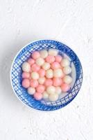 Top view of red and white tangyuan in blue bowl on white background for Winter solstice. photo