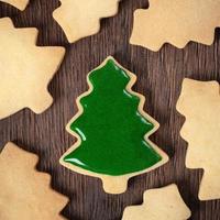 Top view of decorated Christmas tree cookie on wooden table background with copy space. photo