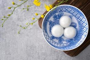 vista superior del gran tangyuan yuanxiao en un tazón sobre fondo gris para la comida del año nuevo lunar. foto