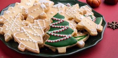 Close up of Christmas sugar cooikes in a plate on red table background. photo