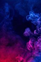 Conceptual image of colorful red and blue color smoke on dark black background. photo