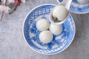 vista superior del gran tangyuan yuanxiao en un tazón sobre fondo gris para la comida del año nuevo lunar. foto