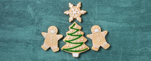 Top view of Christmas tree and snowflake cooikes with gingerbread man wearing mask. photo