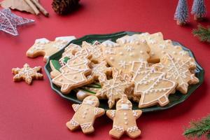 primer plano de cooikes de azúcar de navidad en un plato sobre fondo de mesa rojo. foto