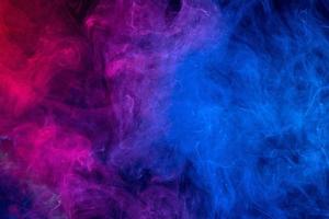 Conceptual image of colorful red and blue color smoke on dark black background. photo