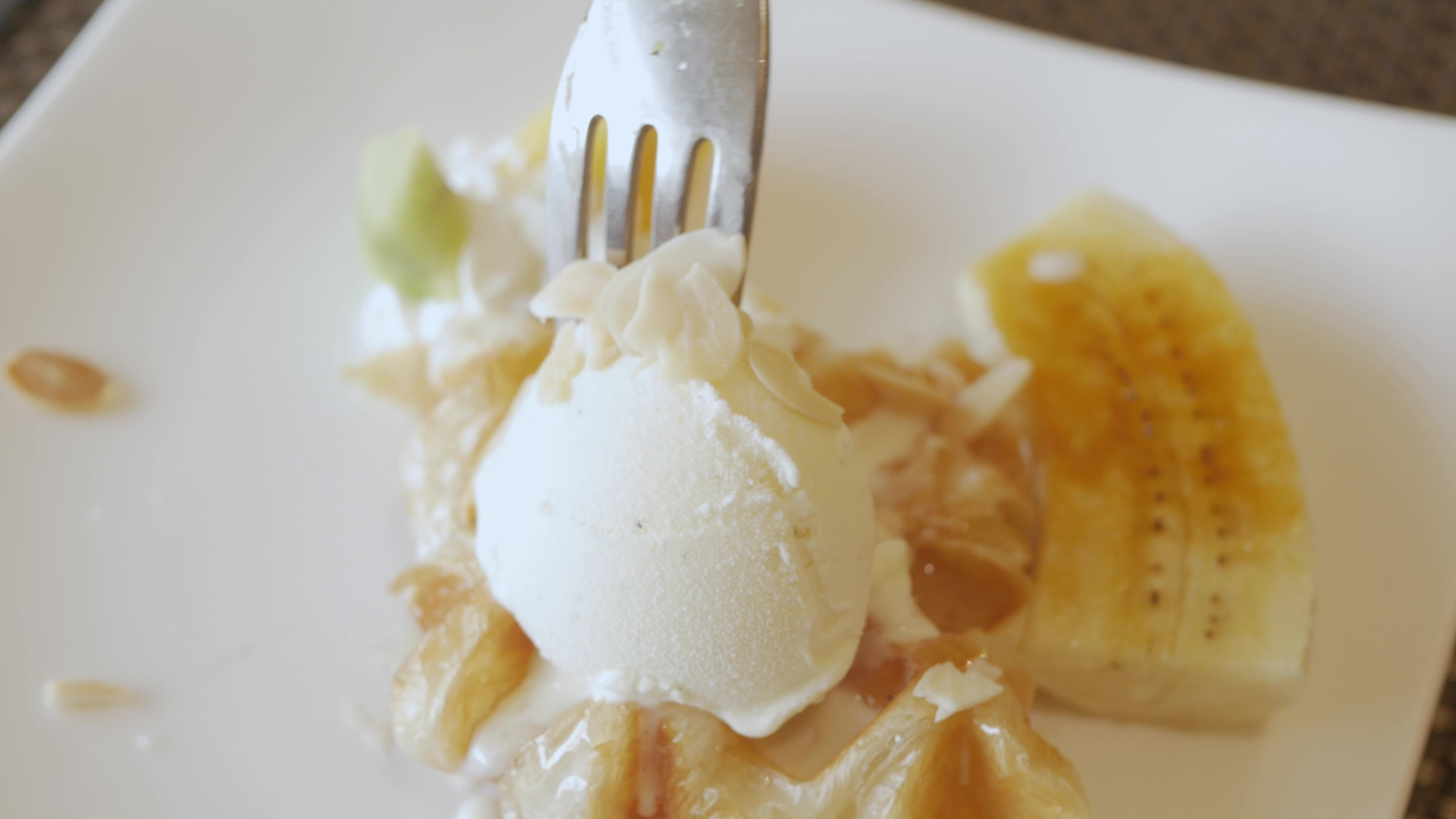 using fork to eat croffle waffles on plate with icecream and caramel