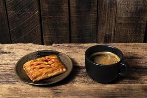 Breakfast food coffee and strawberry pie in plate on wood table. photo