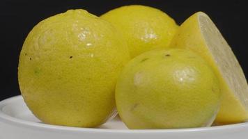 delizioso limone in movimento sul piatto girevole isolare sullo sfondo nero. video