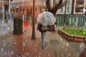 Bilbao, Vizcaya, Spain, 2022 - people with an umbrella on the street in rainy days, autumn season photo