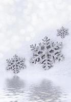 Glass toy snowflake on snow background. photo