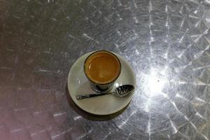 Hot and strong coffee is poured into a cup. photo