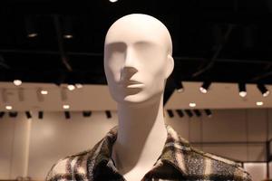 A mannequin stands on a showcase in a store. photo