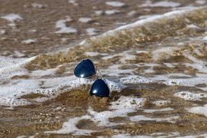 Lost glasses are lying on the sand. photo