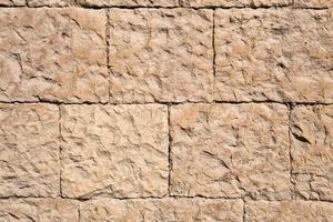 Masonry walls of natural sand color. Stone texture close-up, construction and mining background. photo