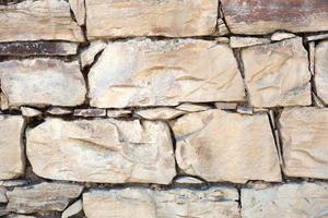 Masonry walls of natural sand color. Stone texture close-up, construction and mining background. photo