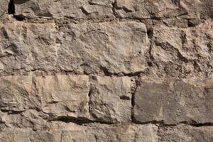 Masonry walls of natural sand color. Stone texture close-up, construction and mining background. photo