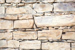 Masonry walls of natural sand color. Stone texture close-up, construction and mining background. photo