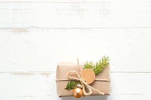 Gift box for Christmas and new year in eco-friendly materials kraft paper, live fir branches, cones, twine. Tags with mock up, natural decor, hand made, DIY. Flatly, background, frame, Minimalism photo