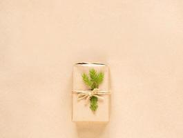 Gift box for Christmas and new year in eco-friendly materials kraft paper, live fir branches, cones, twine. Tags with mock up, natural decor, hand made, DIY. Flatly, background, frame, Minimalism photo