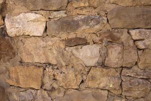 Masonry walls of natural sand color. Stone texture close-up, construction and mining background. photo