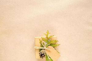 caja de regalo para navidad y año nuevo en materiales ecológicos papel kraft, ramas de abeto vivas, conos, hilo. etiquetas con maqueta, decoración natural, hechas a mano, bricolaje. planamente, fondo, marco, minimalismo foto