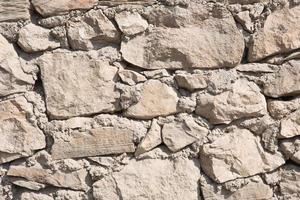 Masonry walls of natural sand color. Stone texture close-up, construction and mining background. photo