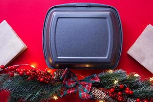 Christmas decor of food delivery service containers. New year's eve promotion. Ready-made hot order, disposable plastic and paper packaging. Work on public holidays catering. Copy space, mock up photo