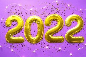 Happy New Year- golden numbers 2022 on a purple background with sequins, stars, glitter, lights of garlands. Greetings, postcard. Calendar, cover. photo