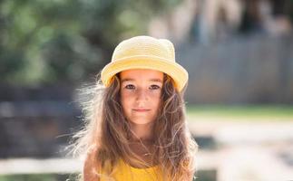 primer plano de un retrato de verano de una niña con un sombrero amarillo y vestido de verano. tiempo soleado de verano, libertad, foto