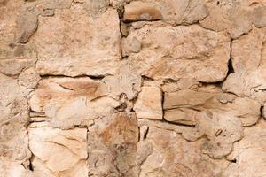 Masonry walls of natural sand color. Stone texture close-up, construction and mining background. photo