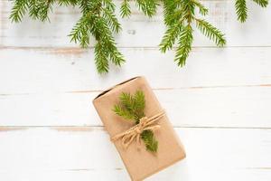 Gift box for Christmas and new year in eco-friendly materials kraft paper, live fir branches, cones, twine. Tags with mock up, natural decor, hand made, DIY. Flatly, background, frame, Minimalism photo