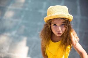 primer plano de un retrato de verano de una niña con un sombrero amarillo y vestido de verano. tiempo soleado de verano, libertad, foto