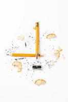 Pencil, metal sharpener and pencil shavings on white background. Vertical image. photo